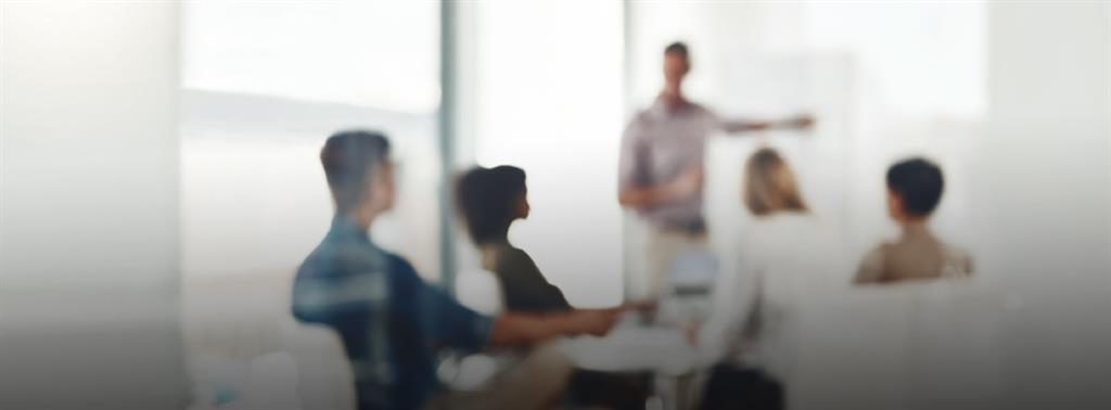 staff sitting in a board room listening to a speaker