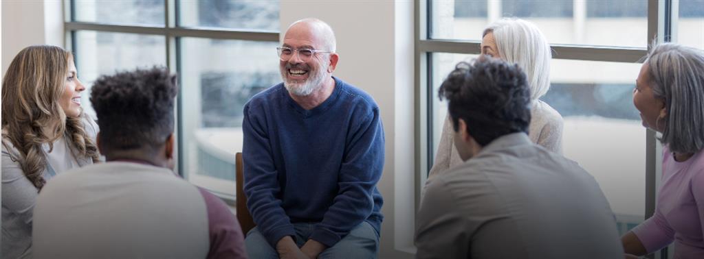 Two older adult couples , looking happy with a palm tree in the background