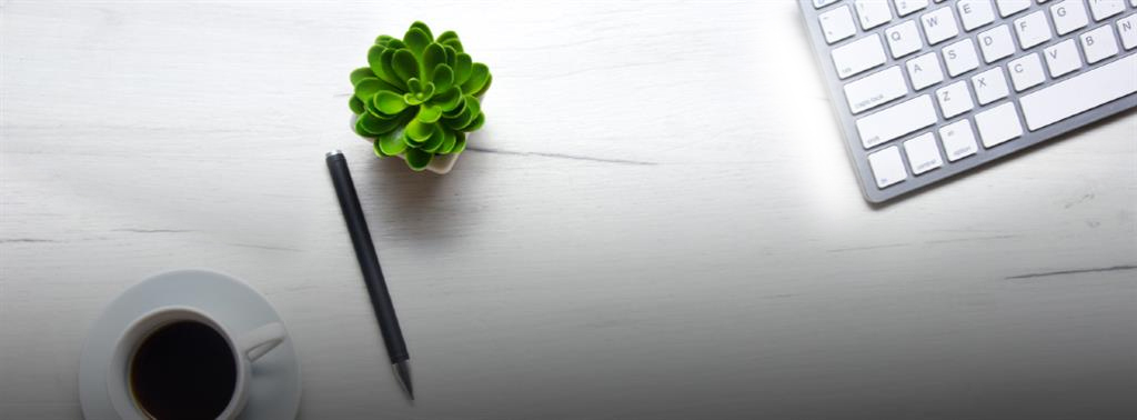 coffe cup, pen, and keyboard on desk